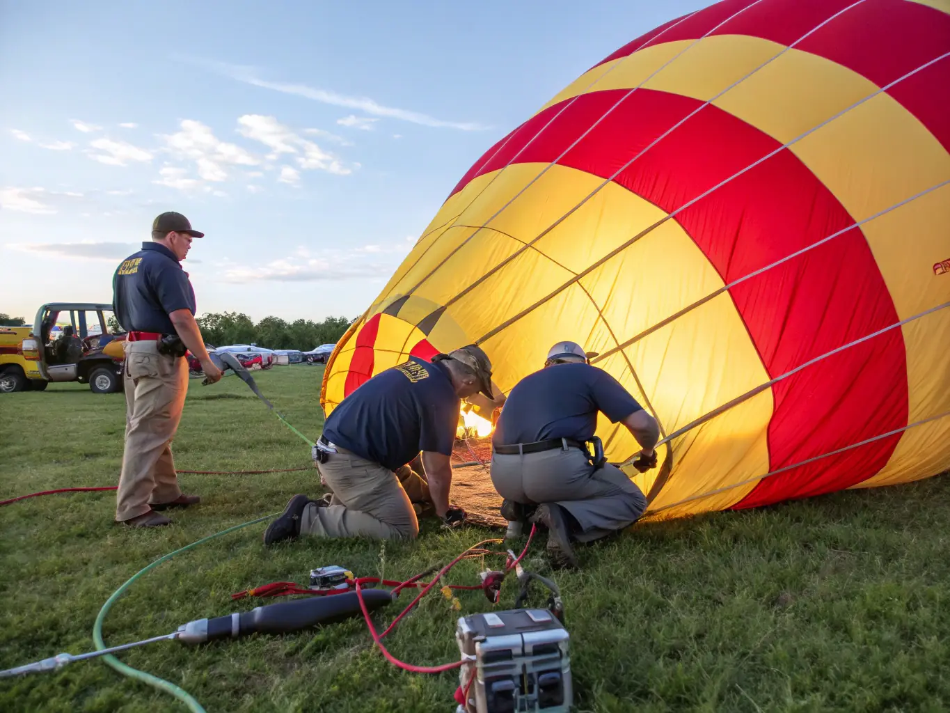 A group of students are gathered around a hot air balloon, learning about the principles of aerostation from an instructor. The scene is educational and engaging, highlighting MONTGOLFIERE EVASION's commitment to promoting aviation knowledge.